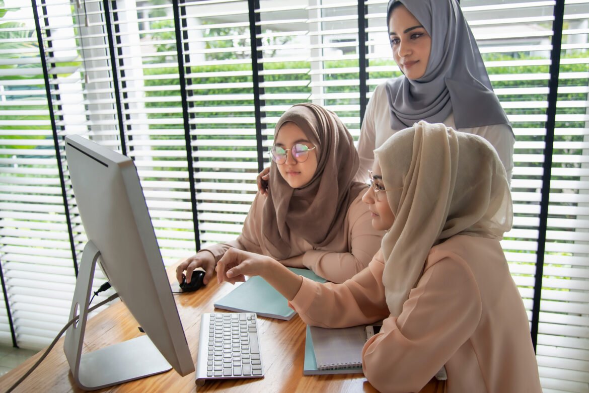 Group of muslim students using and learning with computer.